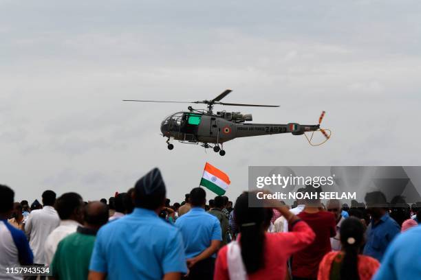 Indian visitors watch a Chetak helicopter take off at the Air Force Station Hakimpet in Hyderabad, on July 27 2019, to mark the Kargil war 20th...