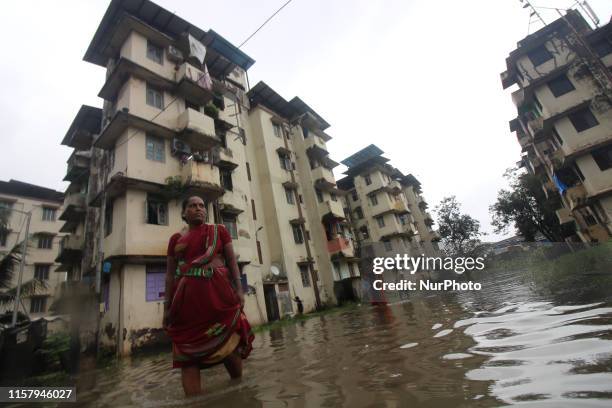 Woman wade through a waterlogged street after heavy rain in Mumbai, India on 27 July 2019. Monsoon in India officially lasts from June to September.