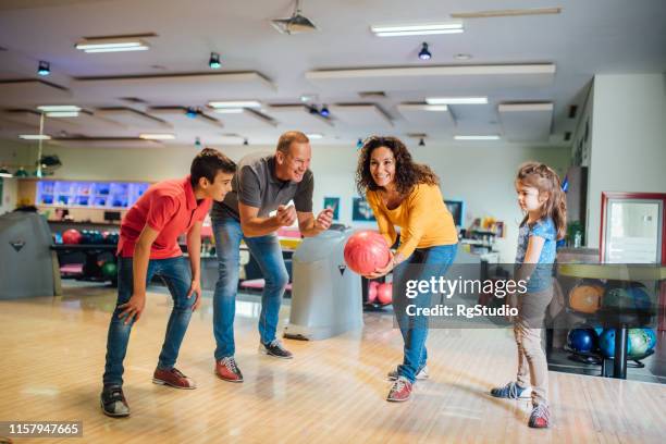 frau bowling mit der familie - family bowling stock-fotos und bilder