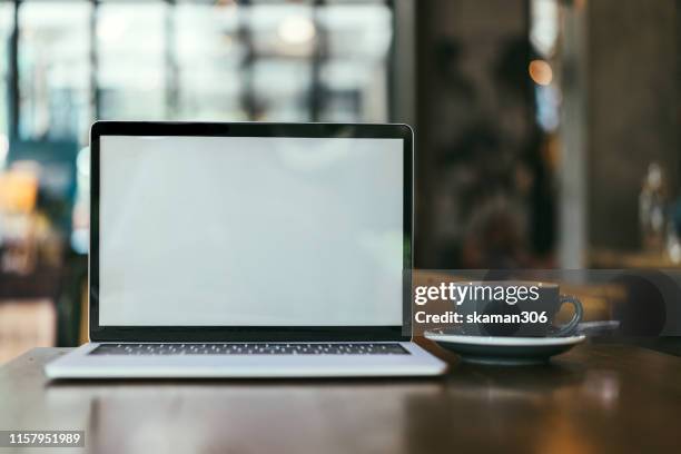 closeup blank screen laptop computer and coffee on wooden table and copyspace - カフェ　テーブル　無人 ストックフォトと画像