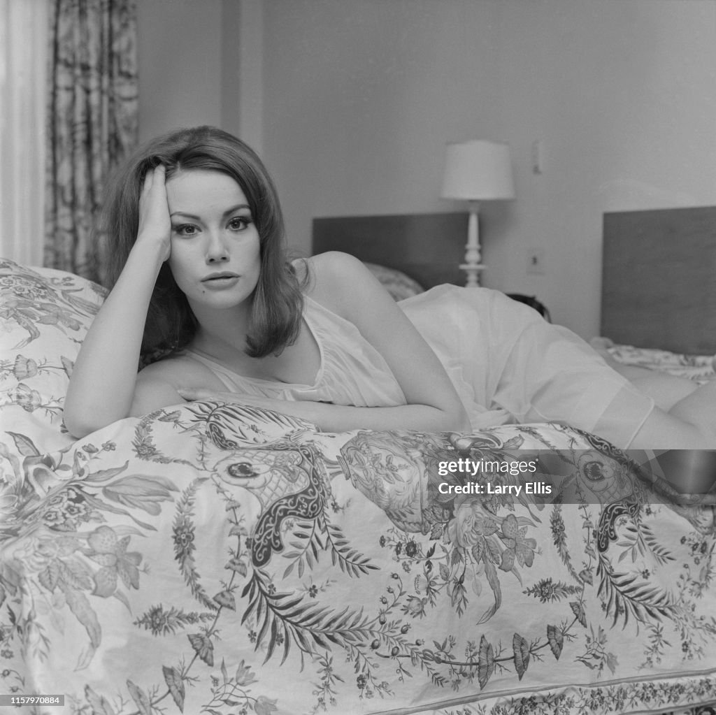 French actress Claudine Auger wearing a negligee as she lies on a
