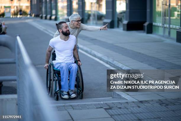 businessman in the wheelchair and mature business woman outside - asking stock pictures, royalty-free photos & images