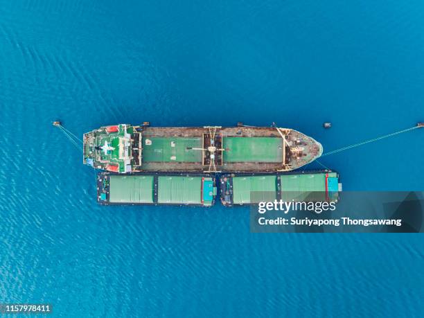 aerial top view rice carrier ship unloading food to small ship for logistics, import export, shipping or transportation. - rice production stockfoto's en -beelden