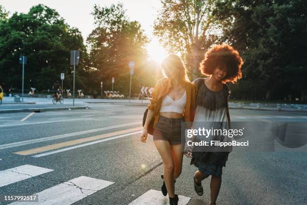 due amici che camminano insieme in città al tramonto - milan street fashion 2019 foto e immagini stock