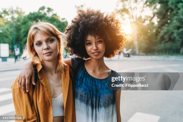 ritratto di due amici insieme in città al tramonto - milan street fashion 2019 foto e immagini stock