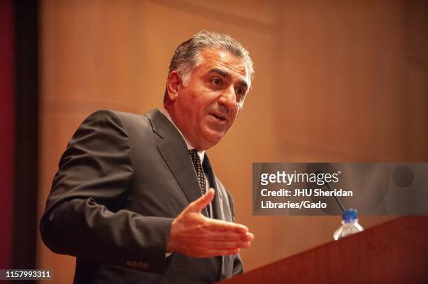 Low-angle close-up of Reza Pahlavi, Crown Prince of Iran, speaking from a podium during a Milton S Eisenhower Symposium at the Johns Hopkins...