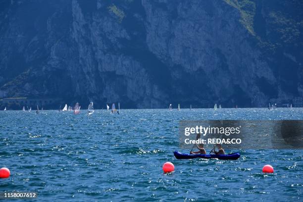 Landscape. Scorcio. Panoramica del Lago di Garda con wind serf. Sport. Estate. Barca a vela. Presso Riva del Garda. Canoa. Cannottaggio. Kayak....