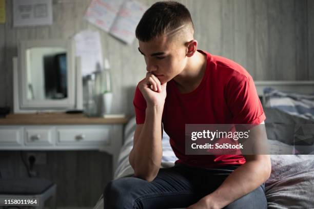 stress über prüfungen - boy sitting on bed stock-fotos und bilder