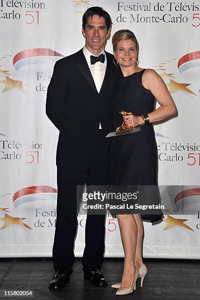 Annette Frier poses with her Golden Nymphe award with Thomas Gibson after the closing ceremony of the 2011 Monte Carlo Television Festival held at...