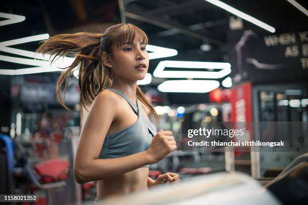 sport woman running on treadmill machine - トレッドミル　女性 ストックフォトと画像
