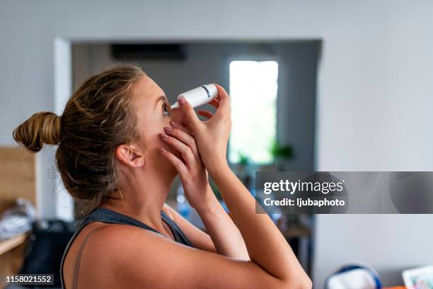 kaukasische frau einfügt augentropfen - augentropfen stock-fotos und bilder