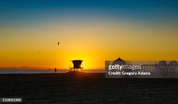 lifeguard station in huntington beach in southern california at sunset - lifeguard tower fotografías e imágenes de stock