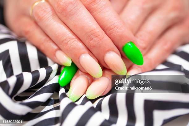 close-up of woman fingers with nail art manicure with neon colour - nagelkunst stockfoto's en -beelden