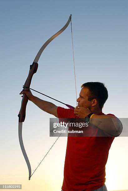 archer pointing his bow and arrow - arrow bow and arrow stock pictures, royalty-free photos & images