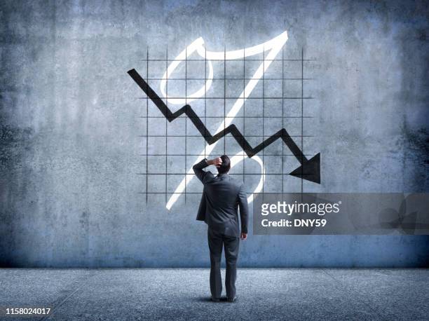 businessman looking up at falling interest rates - slip stock pictures, royalty-free photos & images