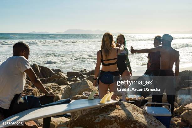 surfer genießen im sommer einen strandgrill - barbeque party woman stock-fotos und bilder