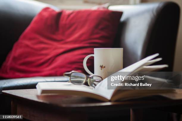 open book, coffee cup and glasses on a table - coffee table reading mug stock pictures, royalty-free photos & images