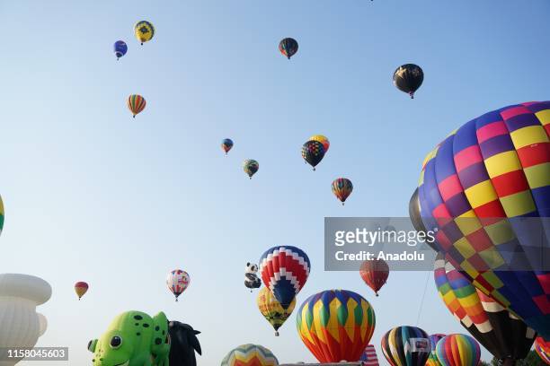 Hot air balloons fly across the sky during the 37nd annual QuickChek New Jersey Festival of Ballooning on July 27, 2019 in Readington, New Jersey.