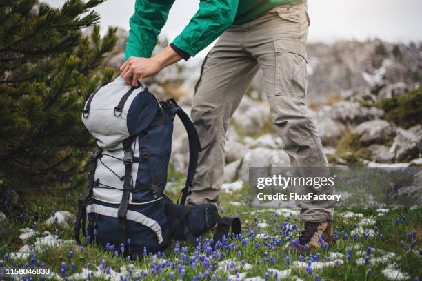 hiker opening his backpack on the mountain - open backpack stock pictures, royalty-free photos & images