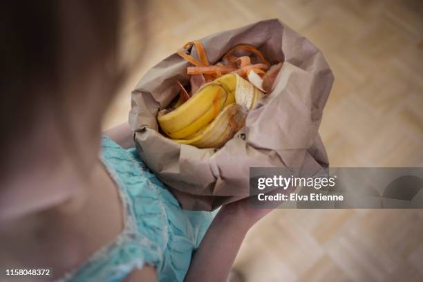 child carrying a biodegradable paper bag full of food scraps - biologisch abbaubar stock-fotos und bilder