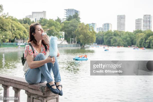 woman eating cotton candy and enjoying the afternoon - mexico city tourist stock pictures, royalty-free photos & images