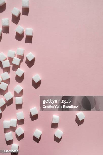 sugar cubes on pink background - zucker stock-fotos und bilder