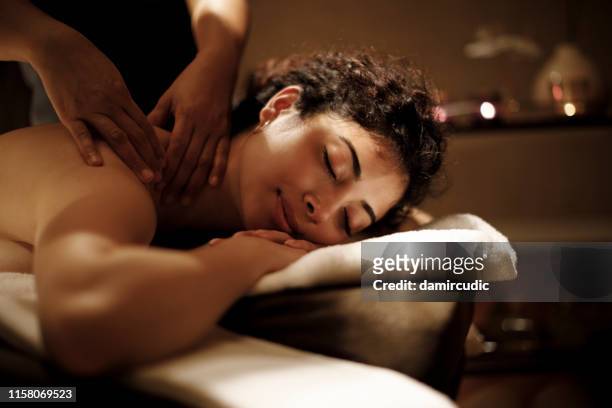 close-up of a beautiful woman receiving back massage at spa - massage therapist woman stock pictures, royalty-free photos & images