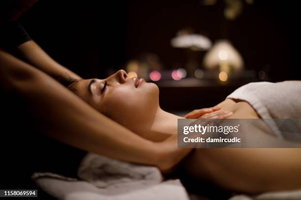 woman enjoying massage in spa center - day spa stock pictures, royalty-free photos & images