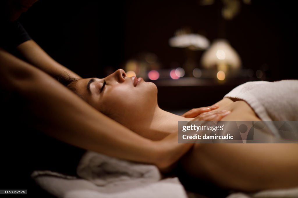 Woman enjoying massage in spa center
