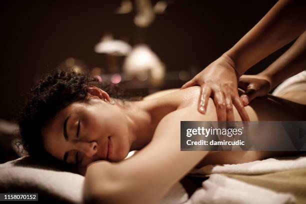 young woman enjoying massage - massage therapy stock pictures, royalty-free photos & images