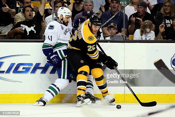 Shawn Thornton of the Boston Bruins fights for the puck against Andrew Alberts of the Vancouver Canucks during Game Four of the 2011 NHL Stanley Cup...