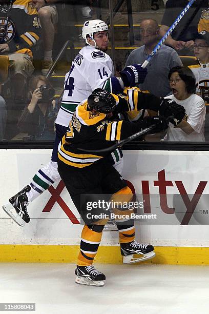 Shawn Thornton of the Boston Bruins checks Alex Burrows of the Vancouver Canucks during Game Four of the 2011 NHL Stanley Cup Final at TD Garden on...