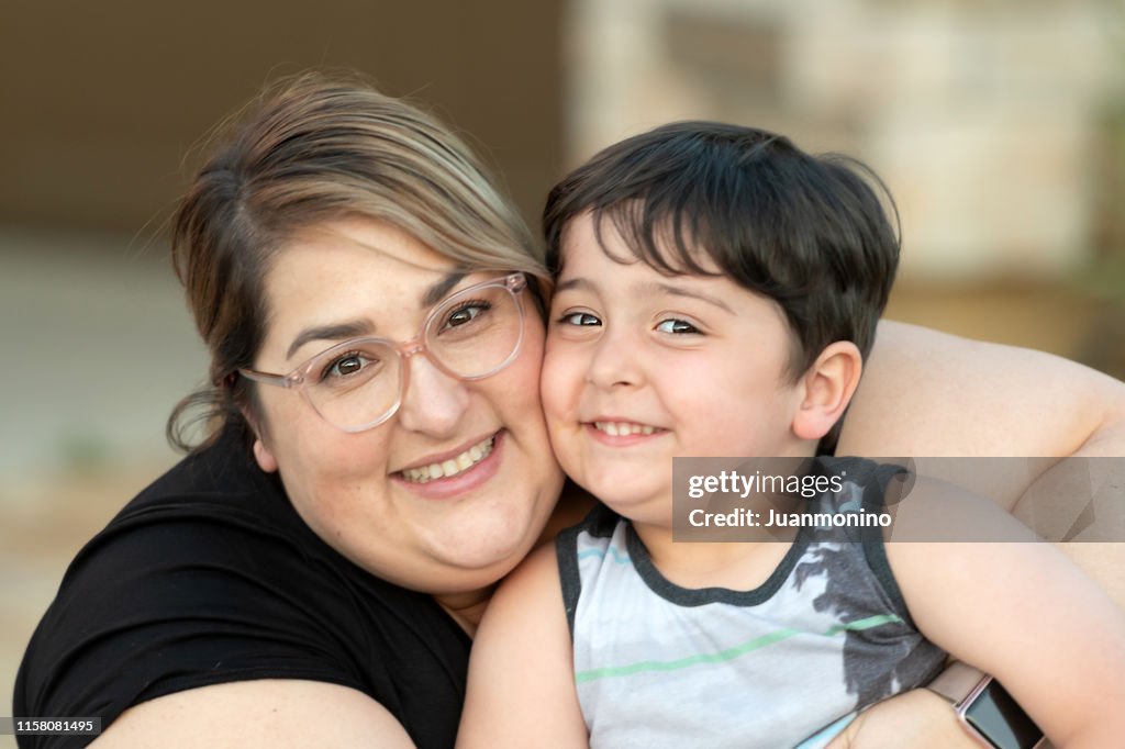 Smiling mid adult woman posing with her son