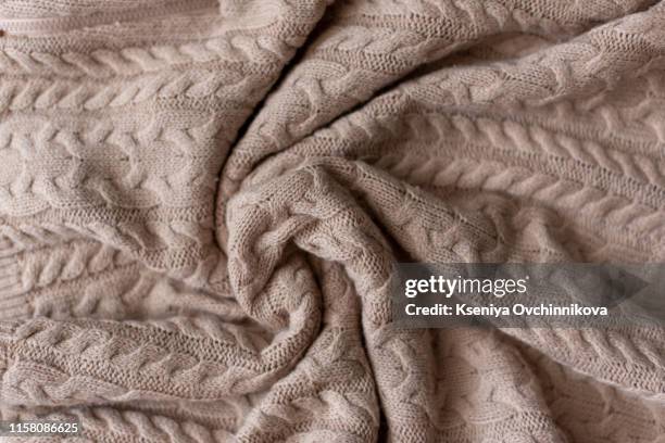 merino wool handmade knitted large blanket, super chunky yarn, trendy concept. close-up of knitted blanket, merino wool background. designer blanket made of beige smoky wool. - wool blanket stock pictures, royalty-free photos & images