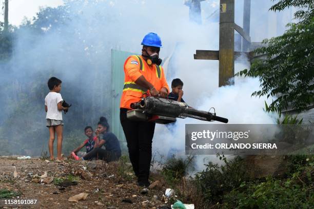An employee of the Permanent Contingency Committee takes part in a fumigation operation to combat Aedes aegypti mosquitoes, vector of the dengue...