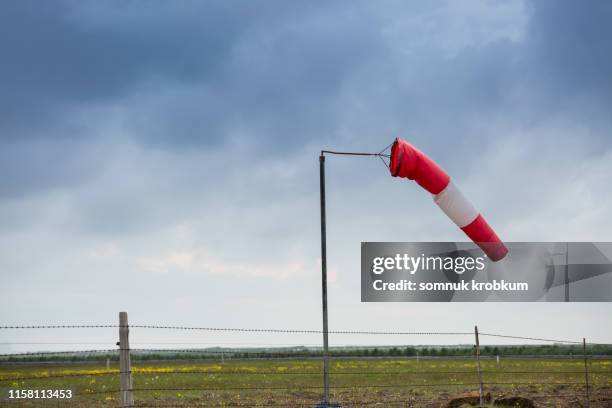 wind sock in field under cloudy sky - wind sock stock pictures, royalty-free photos & images