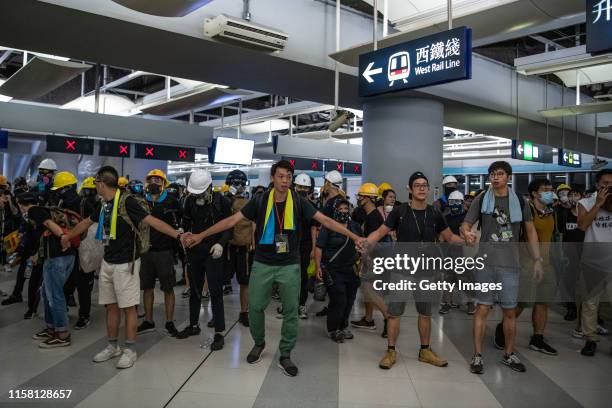 Protesters hold hands inside the metro station during a demonstration in the district of Yuen Long on July 27, 2019 in Hong Kong, China....