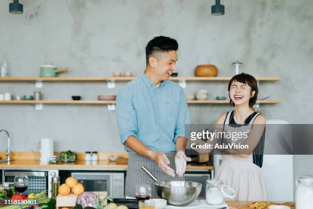 tillgiven unga asiatiska paret ha roligt medan baka tillsammans i en inhemsk kök - asian man cooking bildbanksfoton och bilder