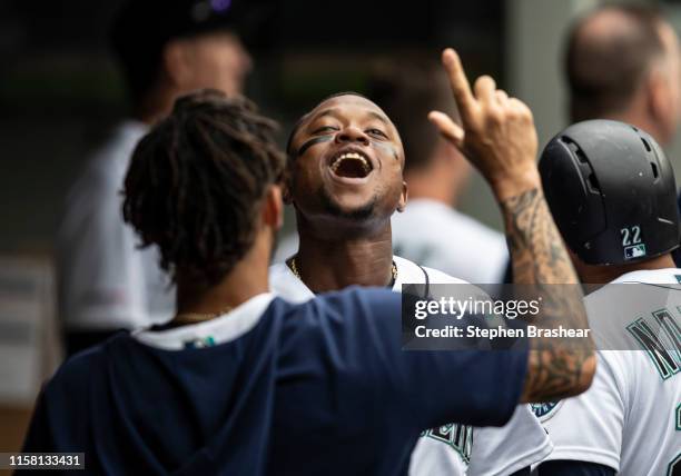 Tim Beckham of the Seattle Mariners celebrates in the dugout after scoring a run on a triple by Austin Nola of the Seattle Mariners off of starting...