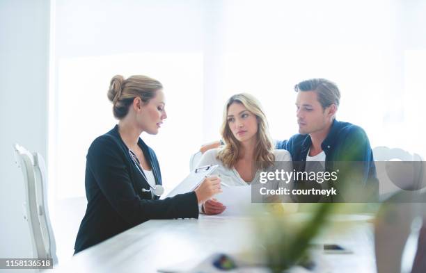 couple meeting with a doctor. - couple doctor stock pictures, royalty-free photos & images