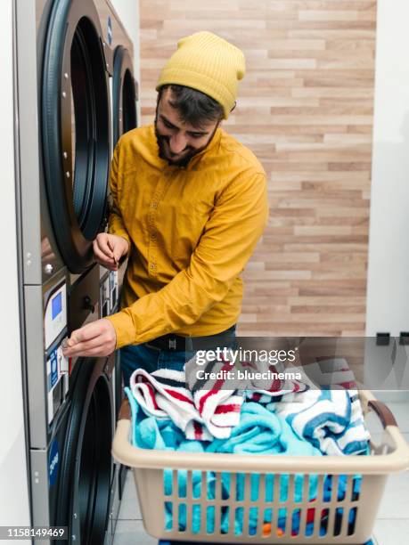 man putting the laundry in the machine - laundry basket stock pictures, royalty-free photos & images