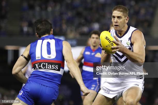 Aaron Sandilands of the Dockers is tackled by Easton Wood of the Bulldogs during the 2019 AFL round 19 match between the Western Bulldogs and the...