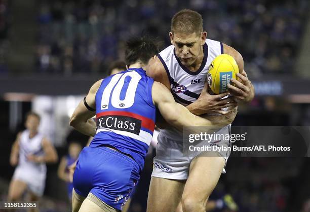 Aaron Sandilands of the Dockers is tackled by Easton Wood of the Bulldogs during the 2019 AFL round 19 match between the Western Bulldogs and the...