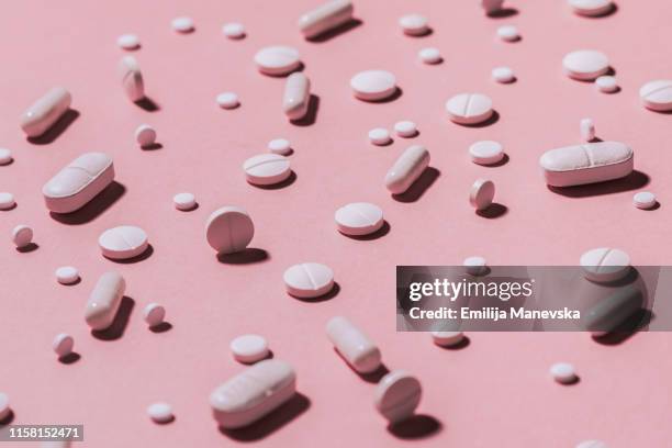 pain killers. pills on pink background - medicine pills stock pictures, royalty-free photos & images