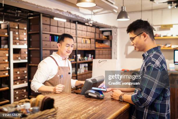 mobile payment in a shoe store - contactless stock pictures, royalty-free photos & images