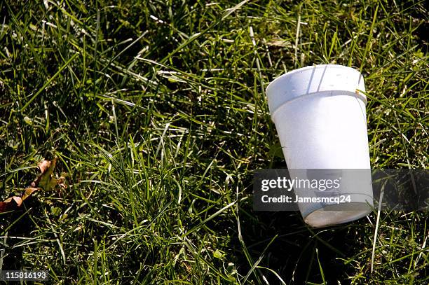 a styrofoam cup on the grass representing litter - styrofoam stockfoto's en -beelden