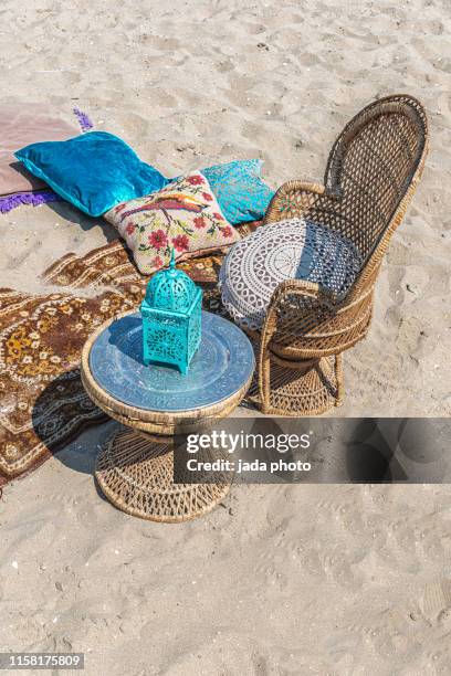 cushions a wicker chair and table with candlestick holder - wicker stock pictures, royalty-free photos & images