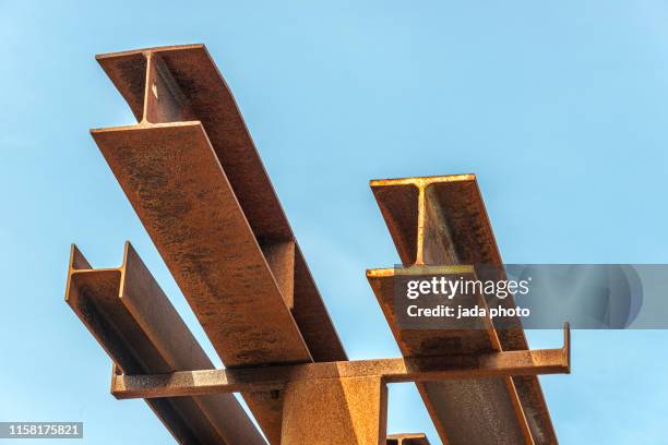 rusty steel beams placed outside on a steel rack - structure abstract stockfoto's en -beelden