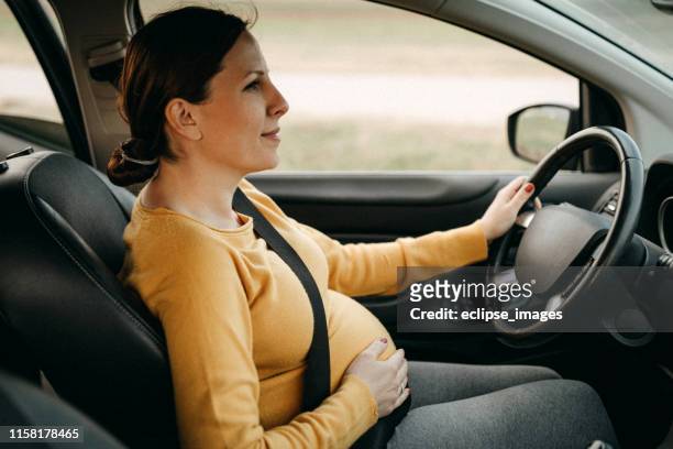 schwangere frau fährt auto - pregnant woman car stock-fotos und bilder