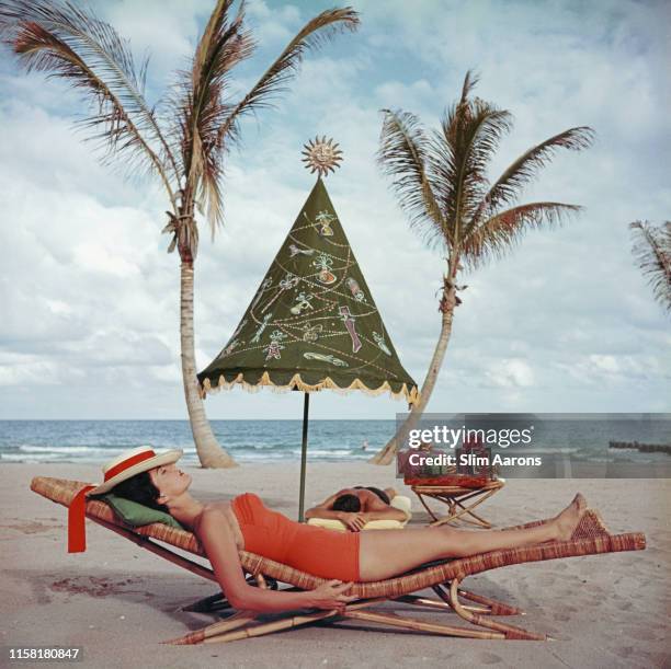 Couple sunbathing by the sea at Palm Beach, Florida, circa 1955.